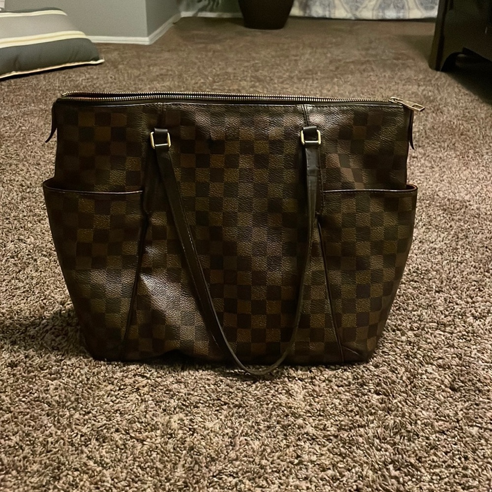 I am selling a Louis Vuitton purse it has a crack on each side.